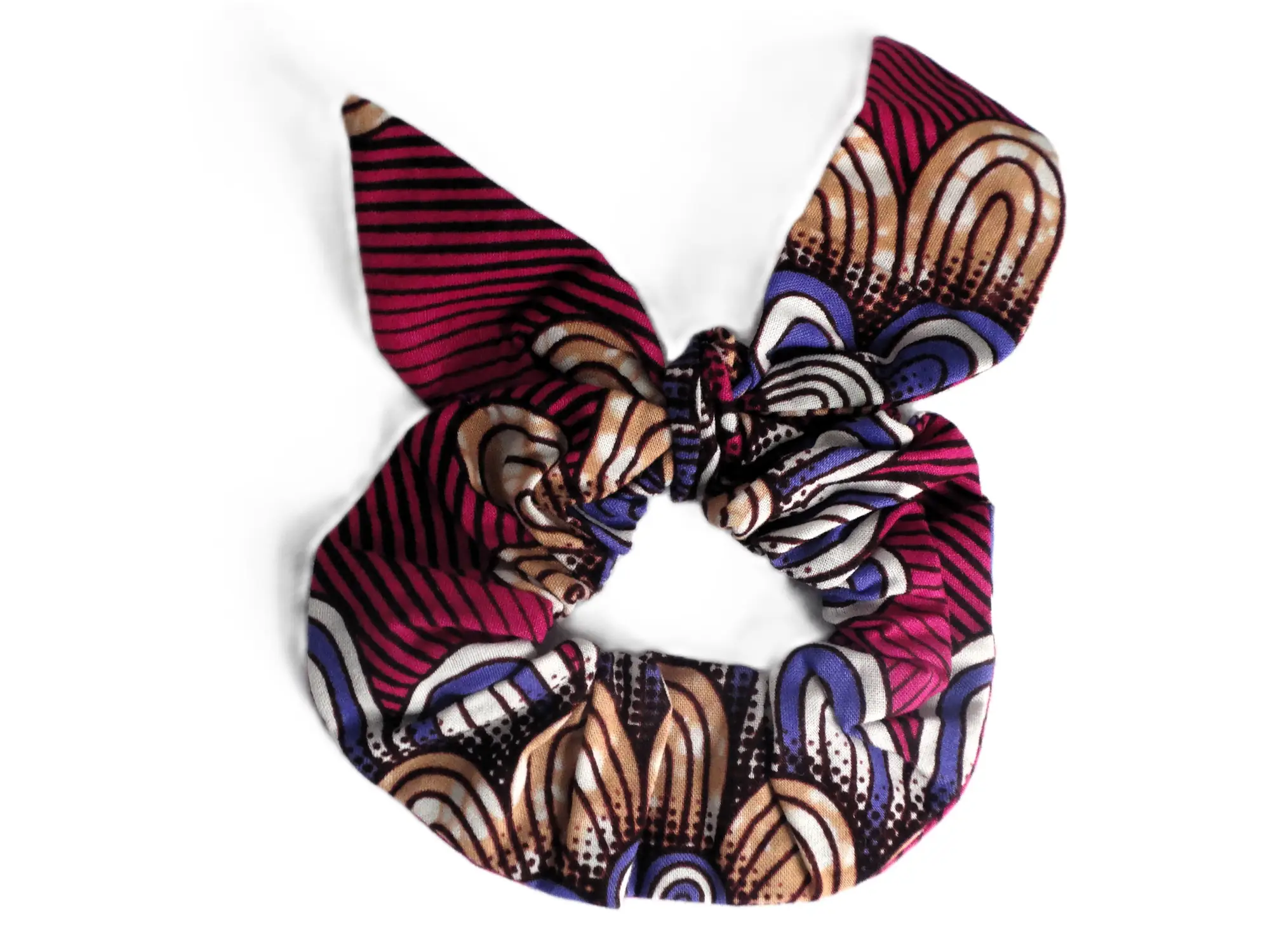 Coletero tipo scrunchie con lazo de la marca MARTIU que utiliza la tela distintiva de la colección en tonos granates y violetas con motivos florales abstractos, diseñado como un accesorio de cabello único y colorido.