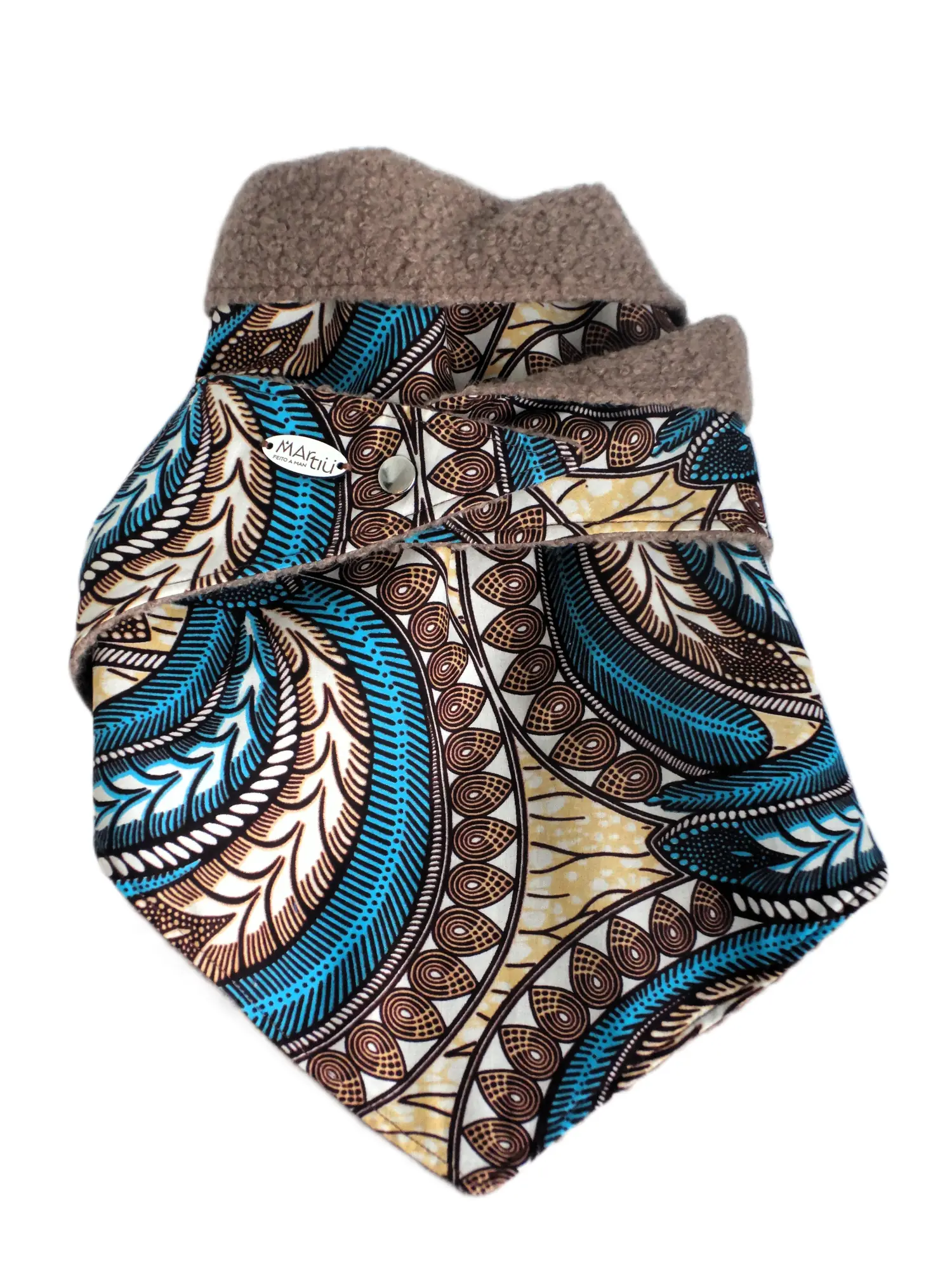 Accesorio de invierno de la marca MARTIU consistente en un cuello de tela estampada con plumas azules, forrado con tejido de borreguito en color marrón para ofrecer confort y un diseño artesanal distintivo.